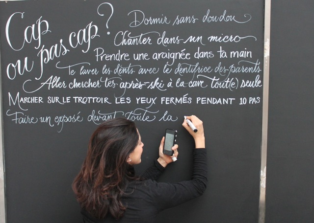 Sarah Hanna calligraphs the walls of La tête à toto' boutique in Cassis, France