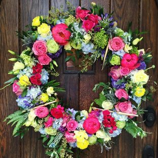 Vibrant floral wreath with paintbrushes | Paint party decor