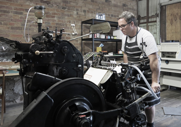 Dave Atkinson of Little Peach Co printing on his cherished Heiderlberg.